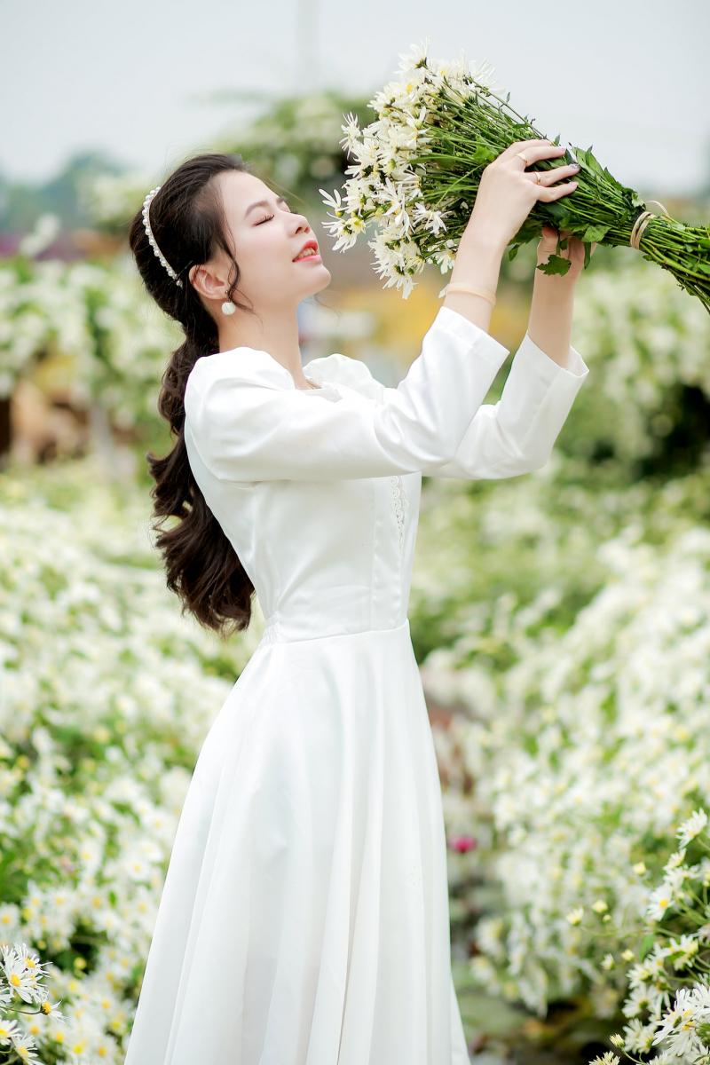 Nâng bó hoa cúc họa mi song song với gương mặt